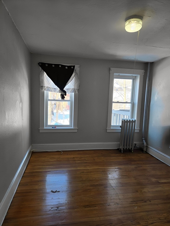 263 Elm Street, Unit 3L Holyoke, MA 01040 - Photo 6 of 12 an empty room with wooden floor and windows