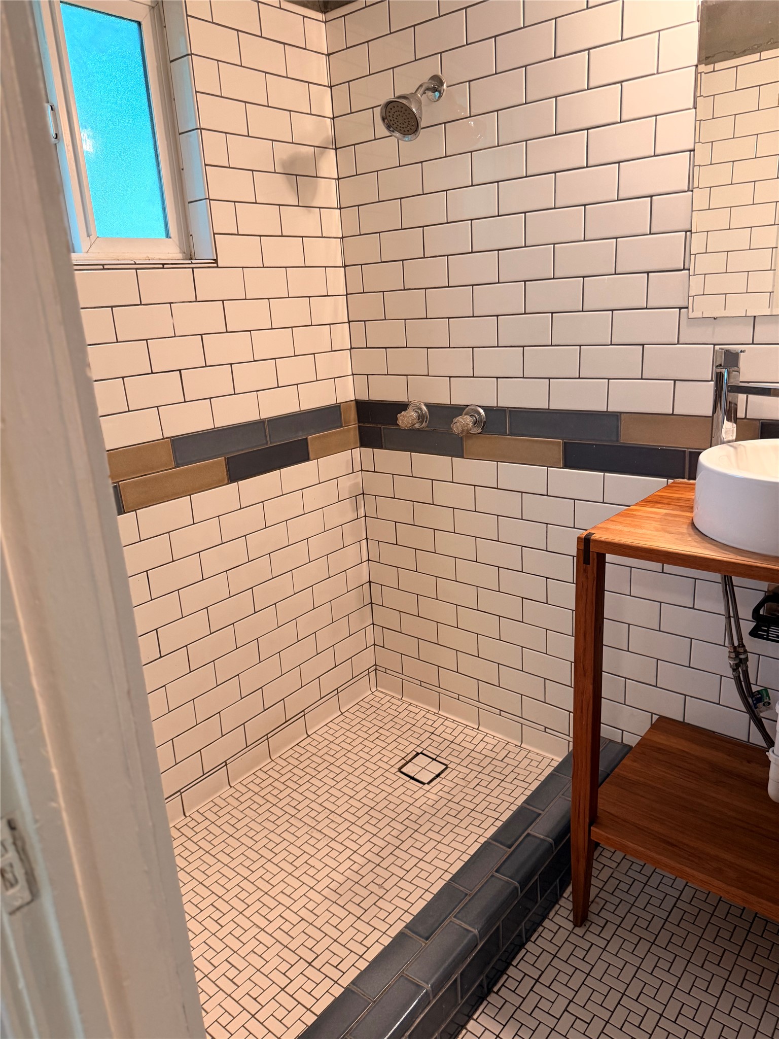 1136 Eleanor Street Austin, TX 78721 - Photo 18 of 30 A well-appointed shower space showcases white subway tiles and mosaic flooring.