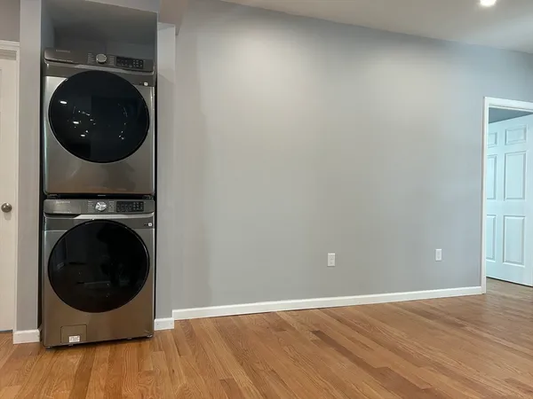 a view of a storage and utility room with wooden floor