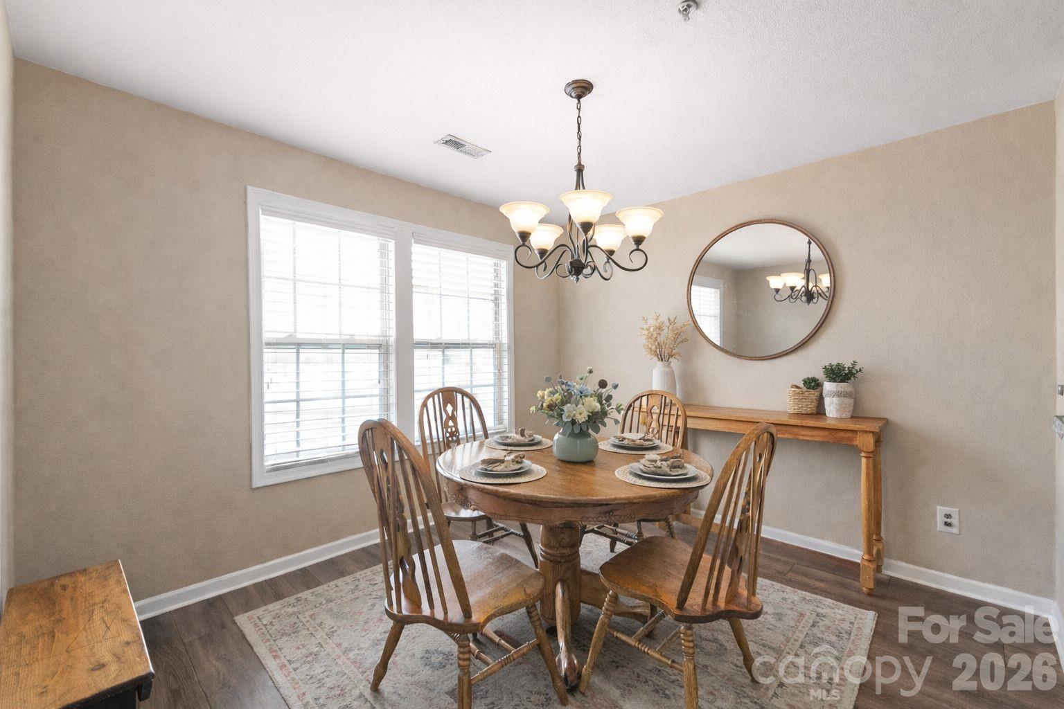 3983 Town Center Road Harrisburg, NC 28075 - Photo 6 of 13 a view of a dining room with furniture a chandelier and wooden floor