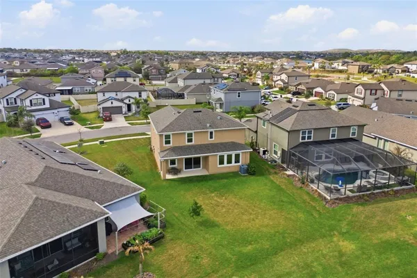 an aerial view of a house with a garden and lake view