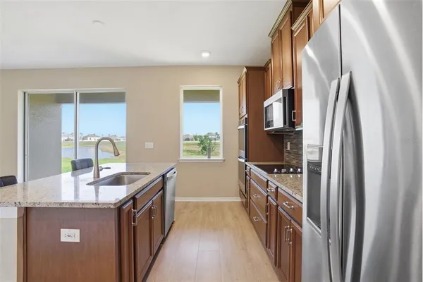 a kitchen with granite countertop a sink and a refrigerator