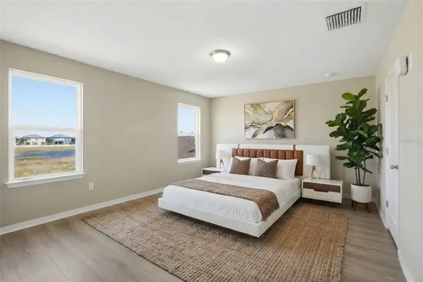 a bedroom with a large bed and a potted plant
