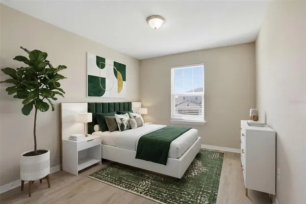 a bedroom with a bed and a potted plant