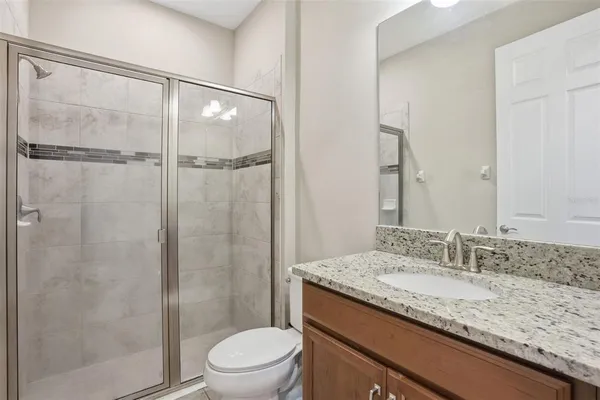 a bathroom with a granite countertop sink toilet and shower