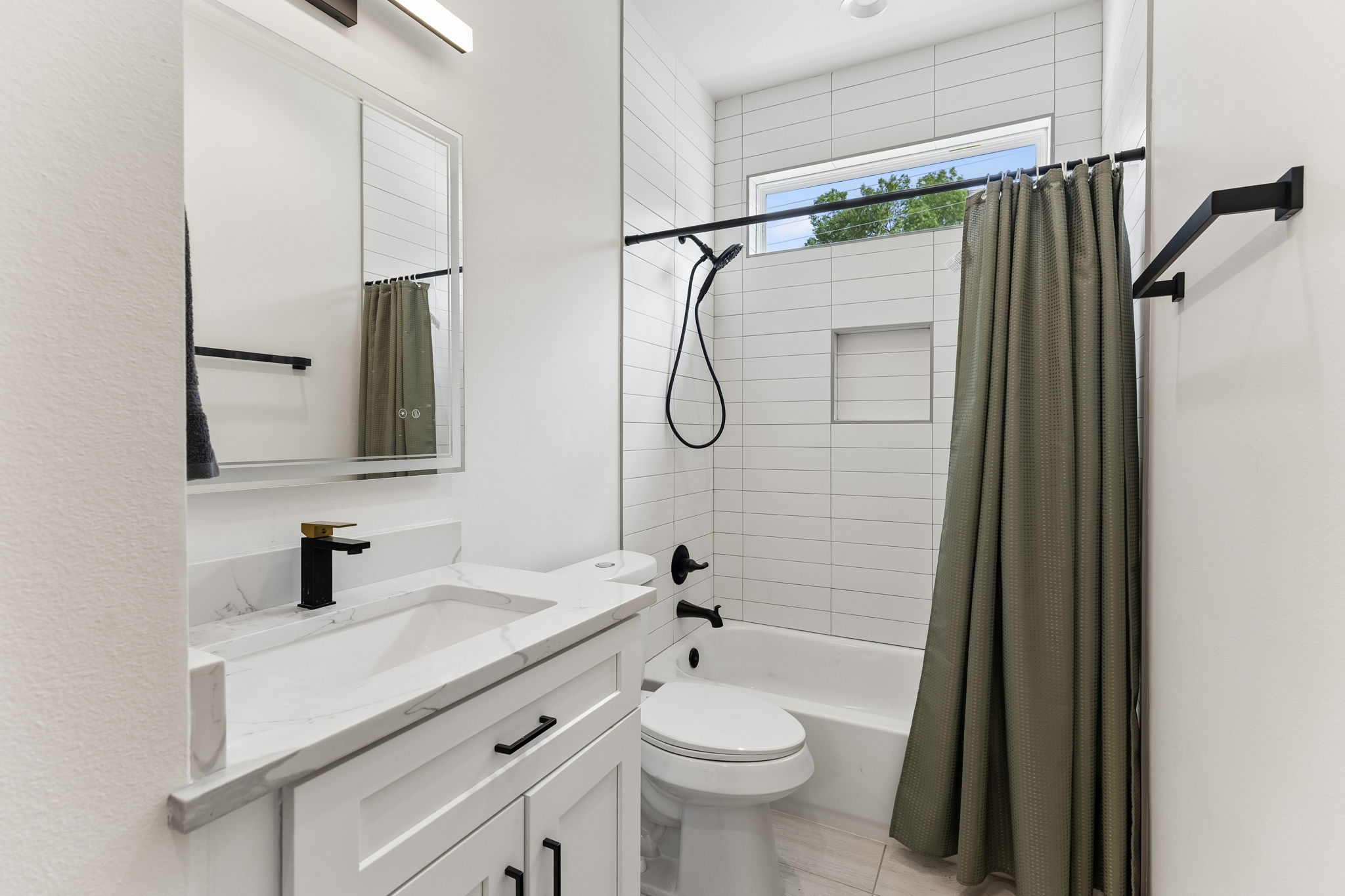 5305 Ledesma Road, Unit 1 Austin, TX 78721 - Photo 22 of 26 Bathroom featuring a white vanity with a rectangular undermount sink, a stone-finish countertop, and a black and gold-tone faucet