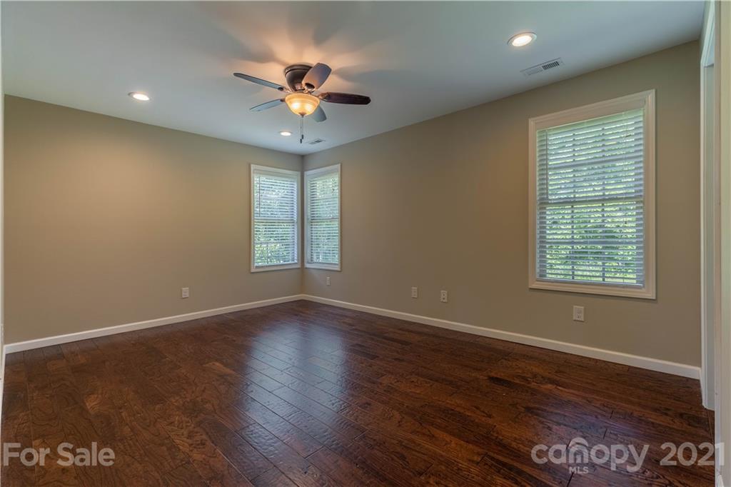 2341 Enola Road Morganton, NC 28655 - Photo 15 of 42 an empty room with wooden floor chandelier fan and windows