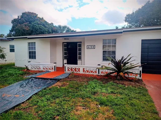 a view of a backyard with plants and patio