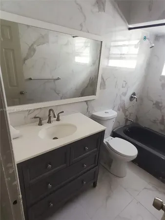 a bathroom with a sink a toilet a mirror and shower