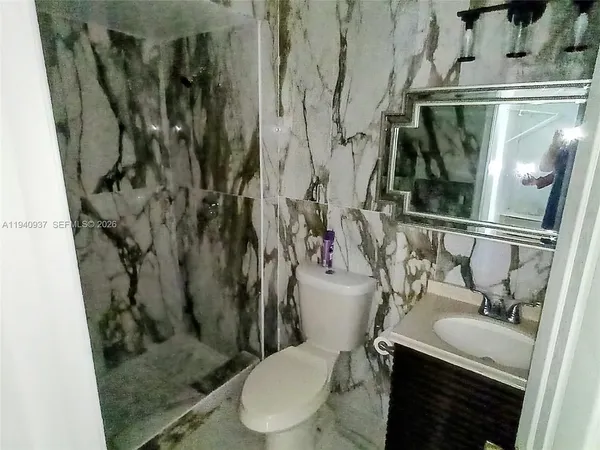a bathroom with a granite countertop sink toilet and shower