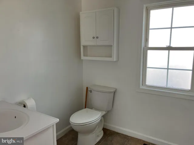 a white toilet sitting next to a window