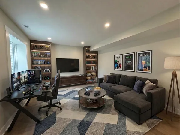 a living room with furniture a wooden floor and a flat screen tv