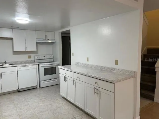 a kitchen with white cabinets and white appliances