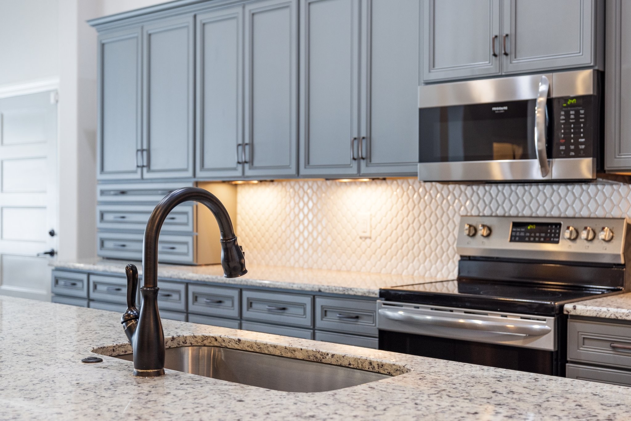 305 McClaran Place Murfreesboro, TN 37129 - Photo 7 of 23 a kitchen with stainless steel appliances kitchen island a stove a sink and a microwave