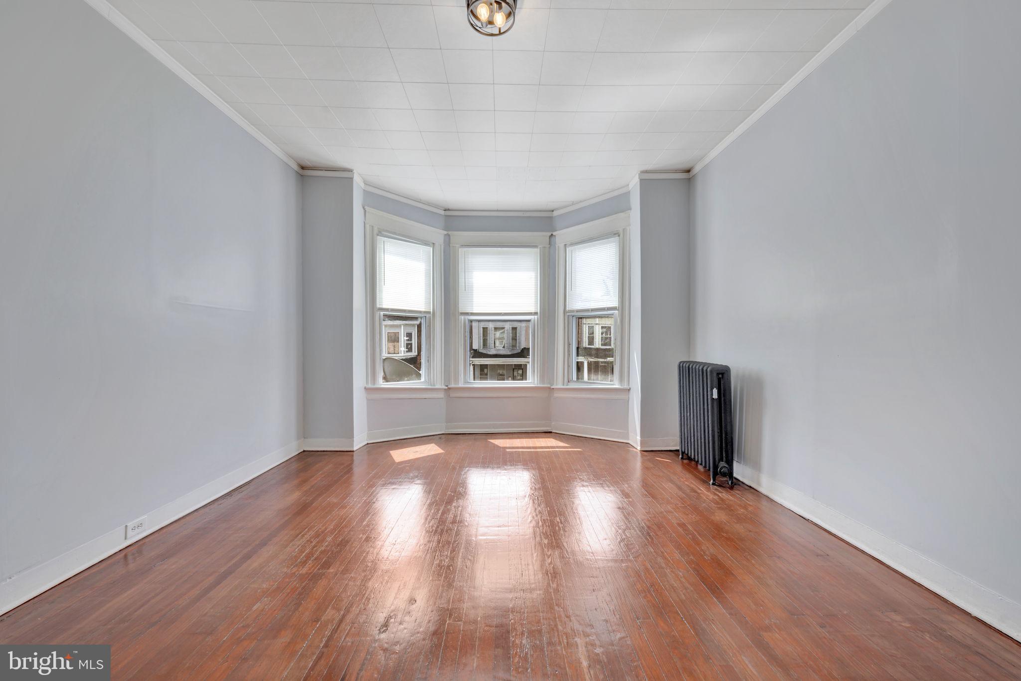 2822 Riggs Avenue Baltimore, MD 21216 - Photo 16 of 30 wooden floor in an empty room with a window