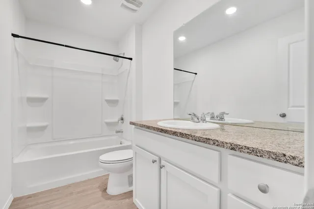 a bathroom with a granite countertop sink toilet and shower