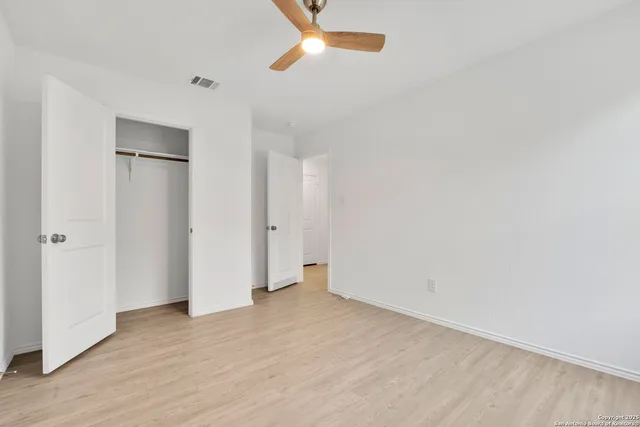 an empty room with wooden floor and closet