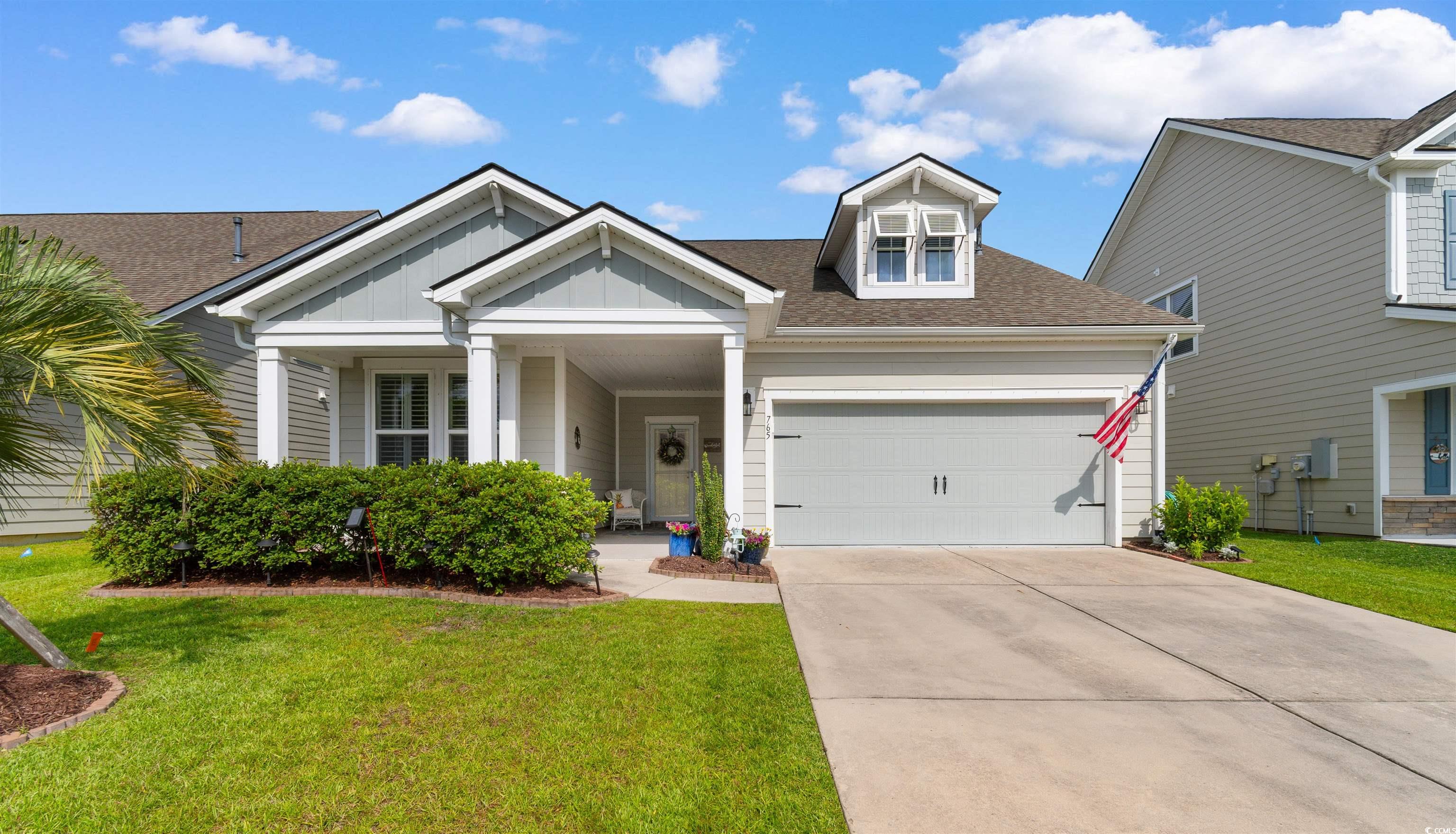 View of front of home with a garage, a front yard, driveway, board and batten siding, and roof with shingles