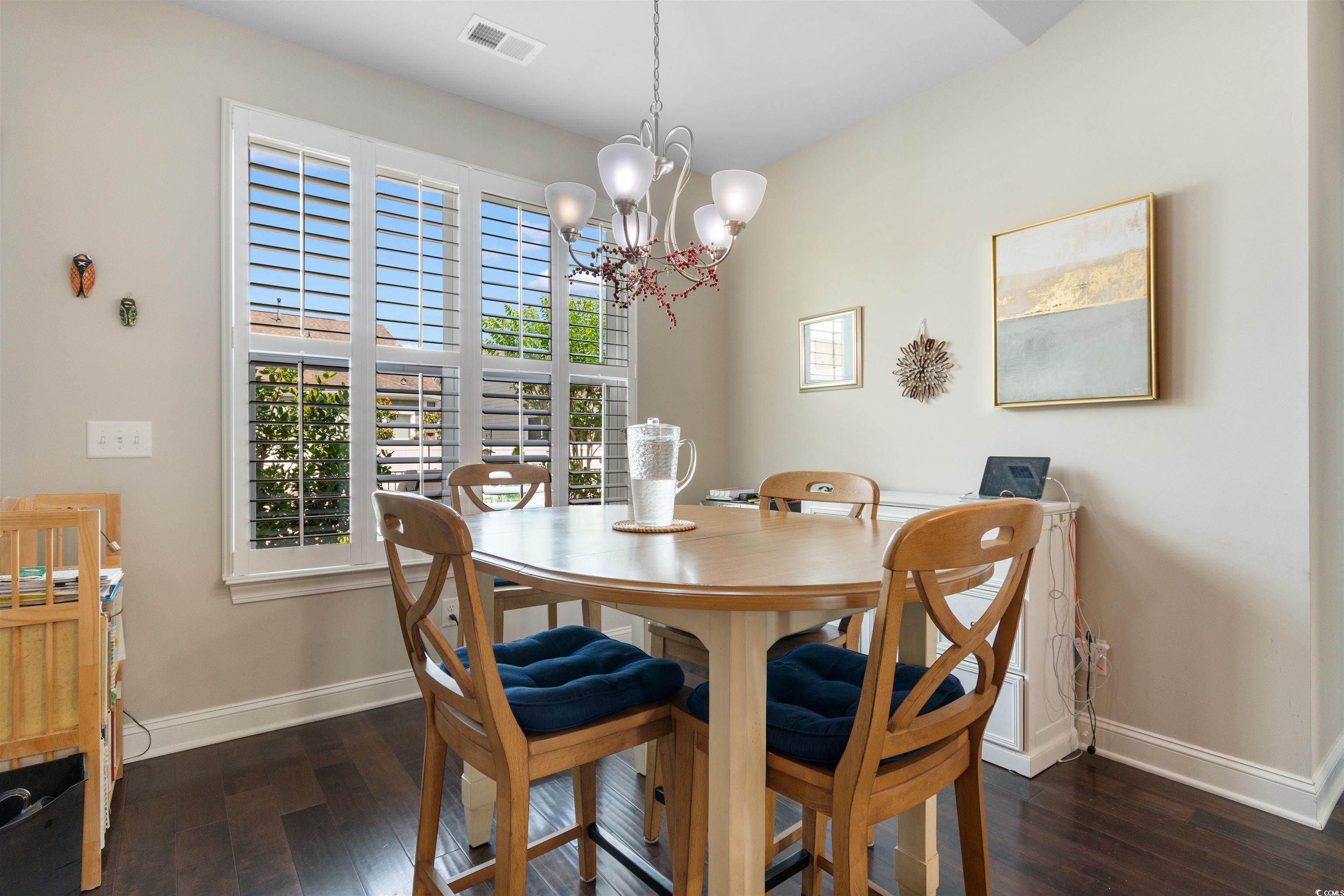 765 Berkshire Avenue Myrtle Beach, SC 29577 - Photo 12 of 40 Dining area featuring baseboards, hardwood / wood-style flooring, and a chandelier