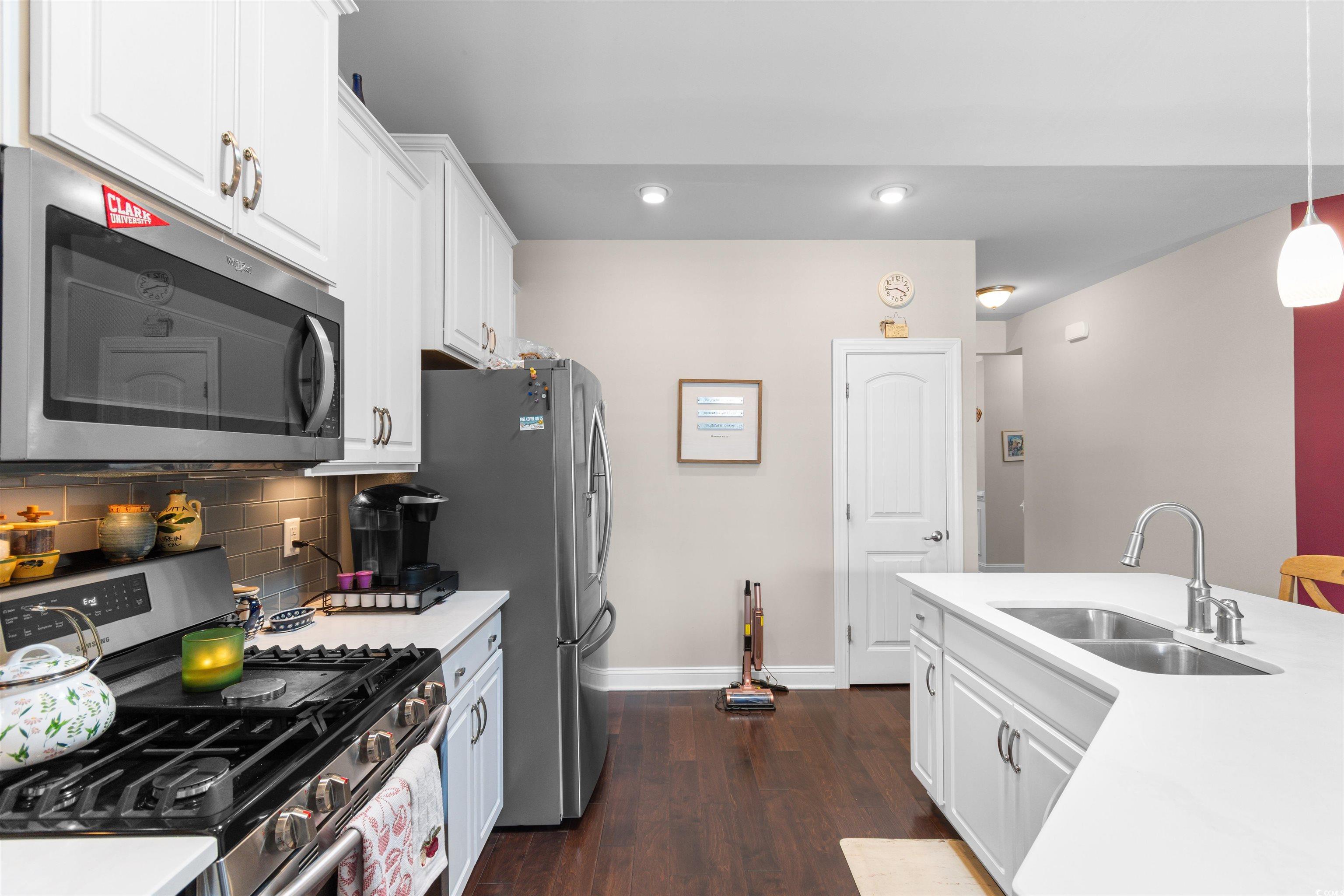 765 Berkshire Avenue Myrtle Beach, SC 29577 - Photo 10 of 40 Kitchen with appliances with stainless steel finishes, a sink, baseboards, dark wood-style floors, and white cabinets