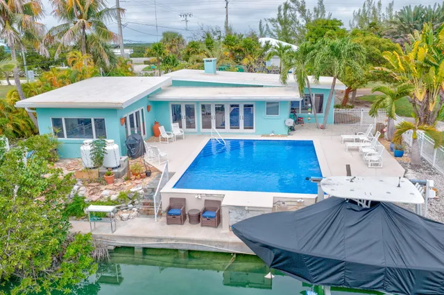 a view of a house with pool and chairs