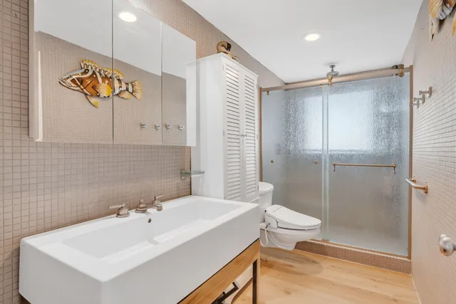 a bedroom with a bed and glass walk in closet