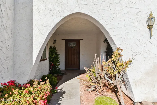 a front view of a house with a lot of flowers
