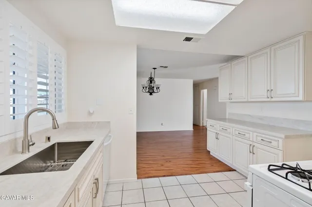 a kitchen with granite countertop a stove a sink and a microwave