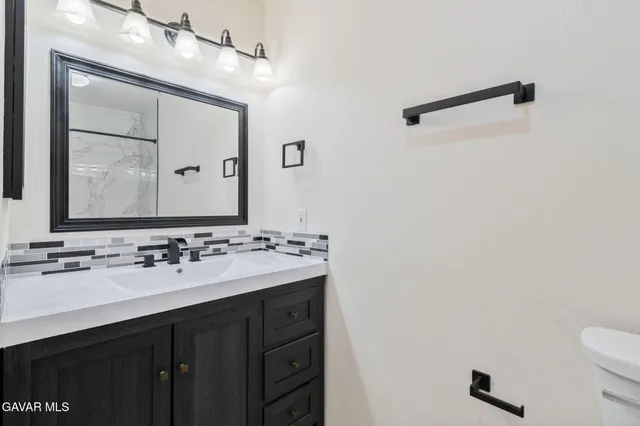 a bathroom with a sink vanity and a mirror