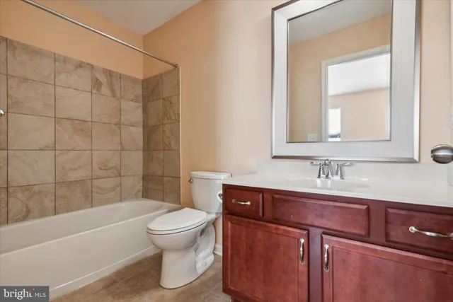 a bathroom with a bathtub shower sink vanity and toilet