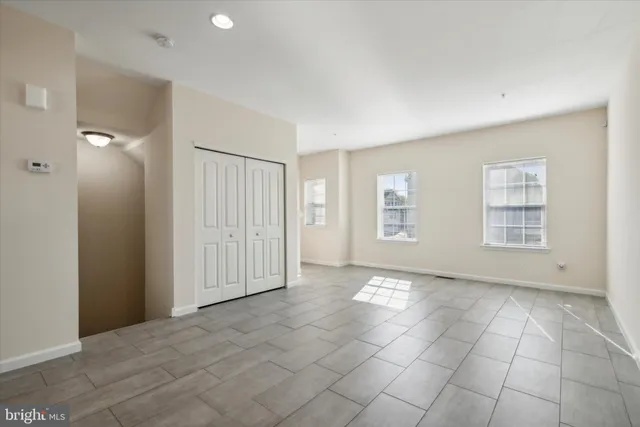 an empty room with windows and closet