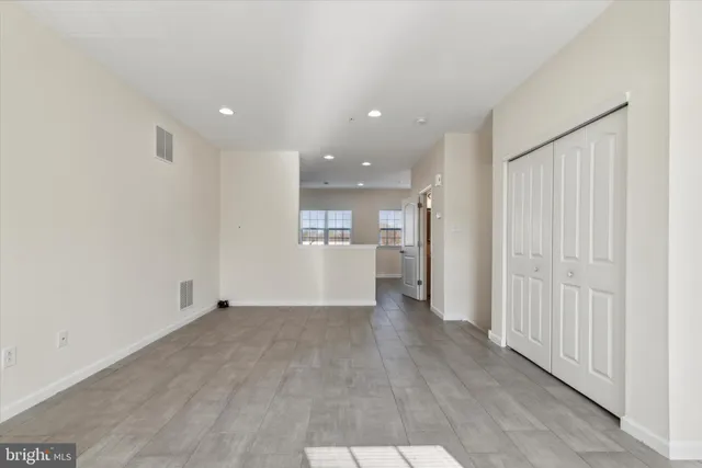 wooden floor in an empty room with a kitchen