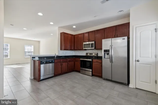 a kitchen with stainless steel appliances granite countertop a refrigerator and a stove