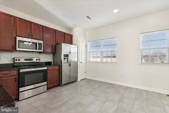a kitchen with stainless steel appliances a refrigerator and a stove top oven
