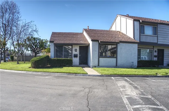 a house view with a backyard space and a car parked in front of it