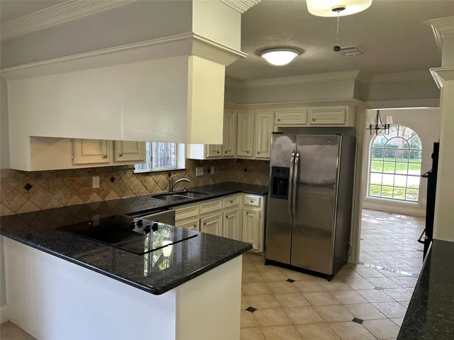 a kitchen with stainless steel appliances granite countertop a sink a stove and a refrigerator