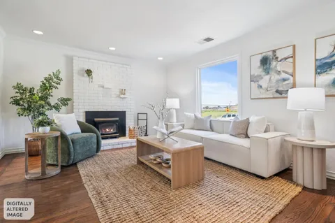 a living room with fireplace furniture and a rug
