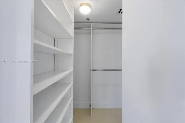 a view of walk in closet with empty racks