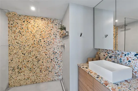 a bathroom with a bathtub sink vanity and shower