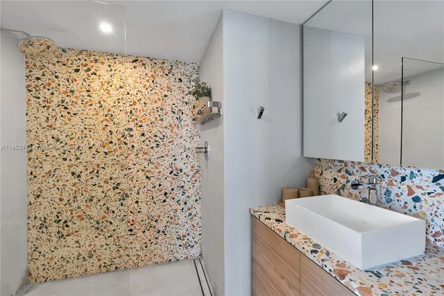 a bathroom with a bathtub sink vanity and shower