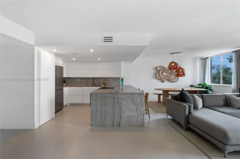 a living room with furniture and a kitchen view
