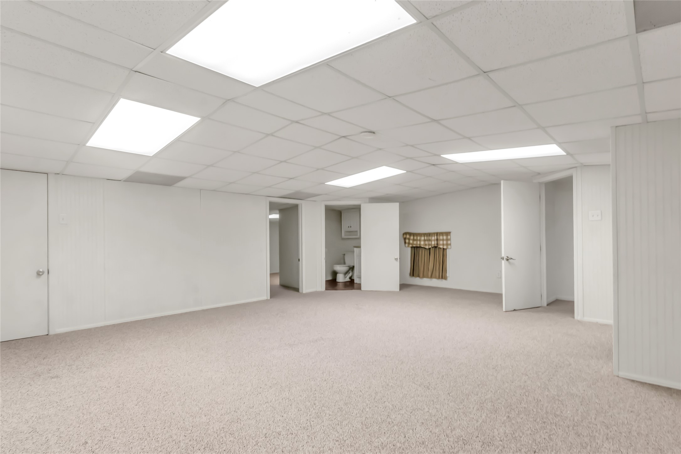 1004 22 Hills Road Gause, TX 77857 - Photo 34 of 37 A spacious, neutral-toned room with plush carpet, bright overhead lighting, and convenient interior access.