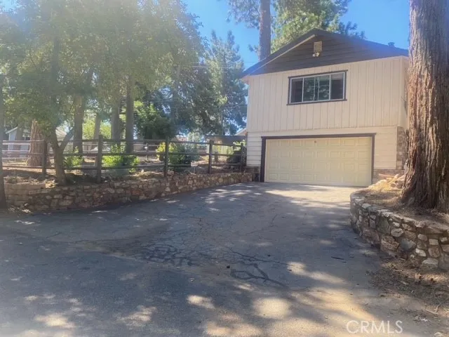 a view of a backyard with table and chairs with a fire pit and a large tree