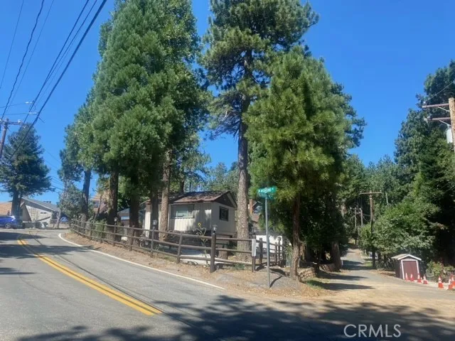 a view of a small house with wooden fence and potted plants