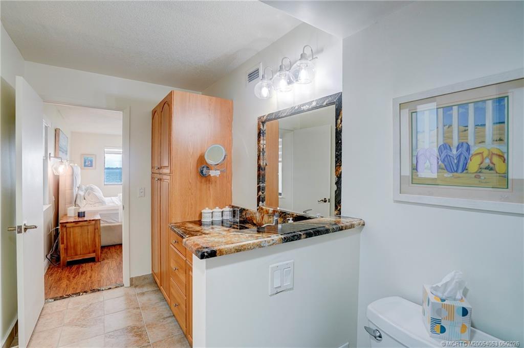 10 Northeast Plantation Road, Unit 101 Jensen Beach, FL 34957 - Photo 48 of 53 a bathroom with a double vanity sink mirror and toilet