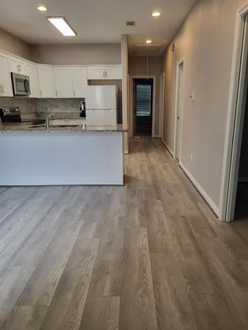 a large kitchen with stainless steel appliances granite countertop a stove a sink and a refrigerator