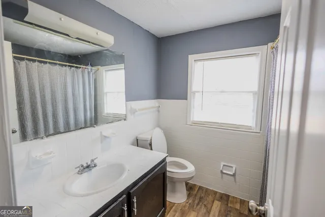 a bathroom with a toilet a sink and a window