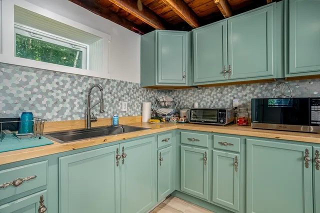 a kitchen with stainless steel appliances granite countertop white cabinets sink and dishwasher a stove with wooden floor