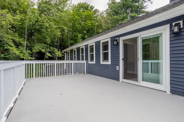 a view of backyard with deck and outdoor seating