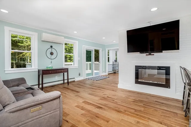 a living room with furniture a flat screen tv and a fireplace